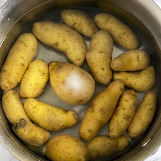 Potatoes boiling in water with salt and baking soda.