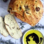 Rosemary and Olive Bread on a marble slab served with olive oil and balsamic vinegar.