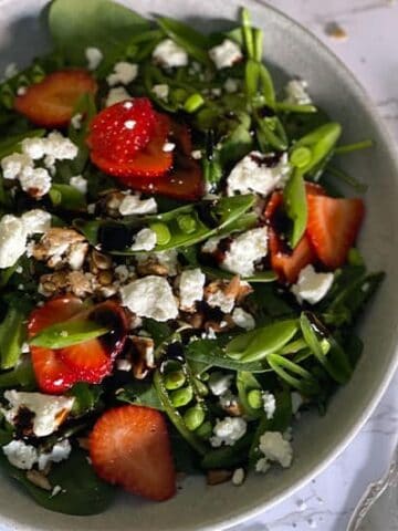 Strawberry Spinach Salad in a white bowl with and fork