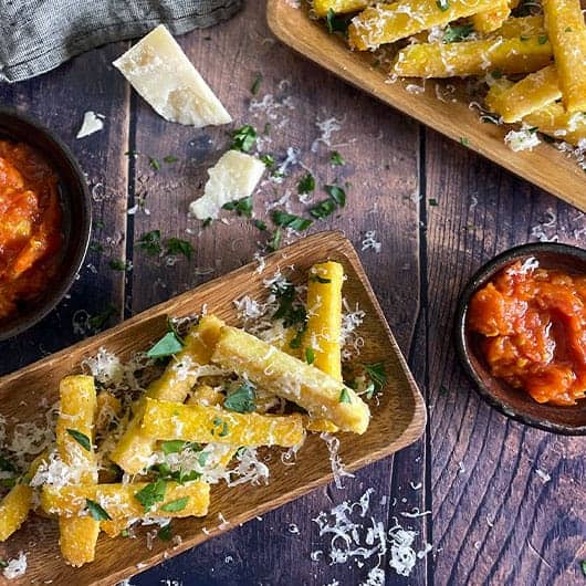 Polenta fries in wooden trays with marinara sauce.