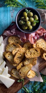 The Best Crostini Toasts with olives on a cutting board.