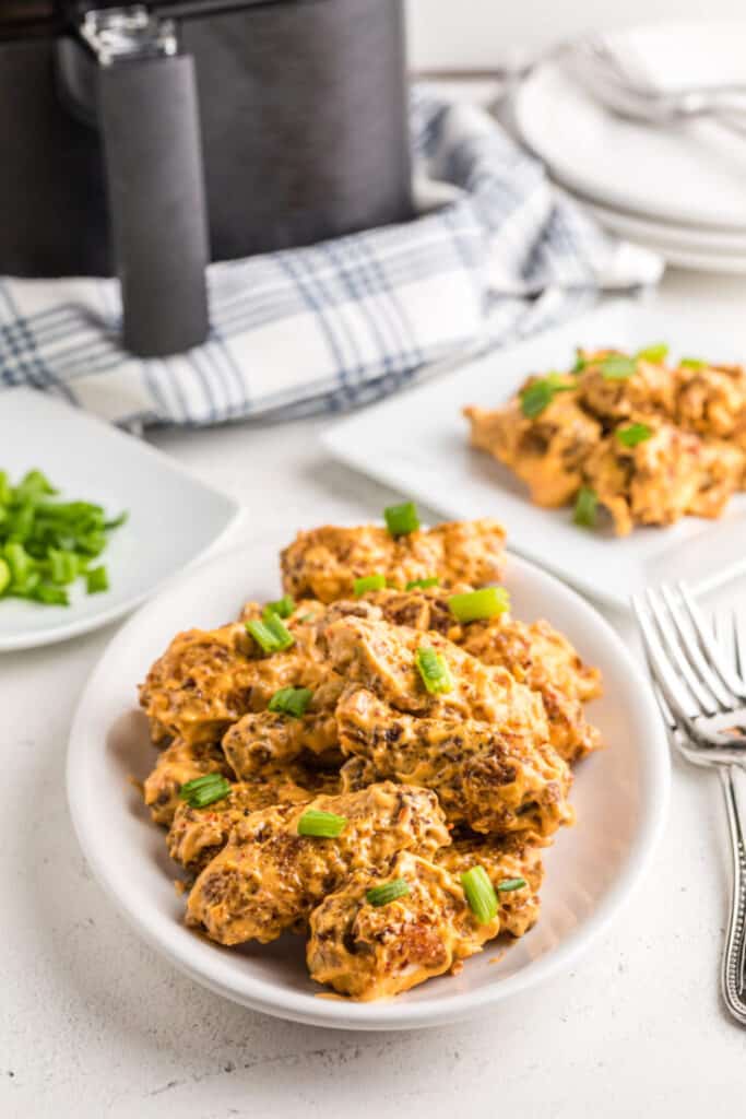 Air-Fryer-Bang-Bang-Chicken-Wings on a white plate with a white background and fork