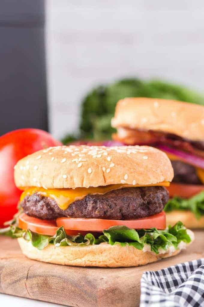 Side view of a cheeseburger with a bun with lettuce and tomato