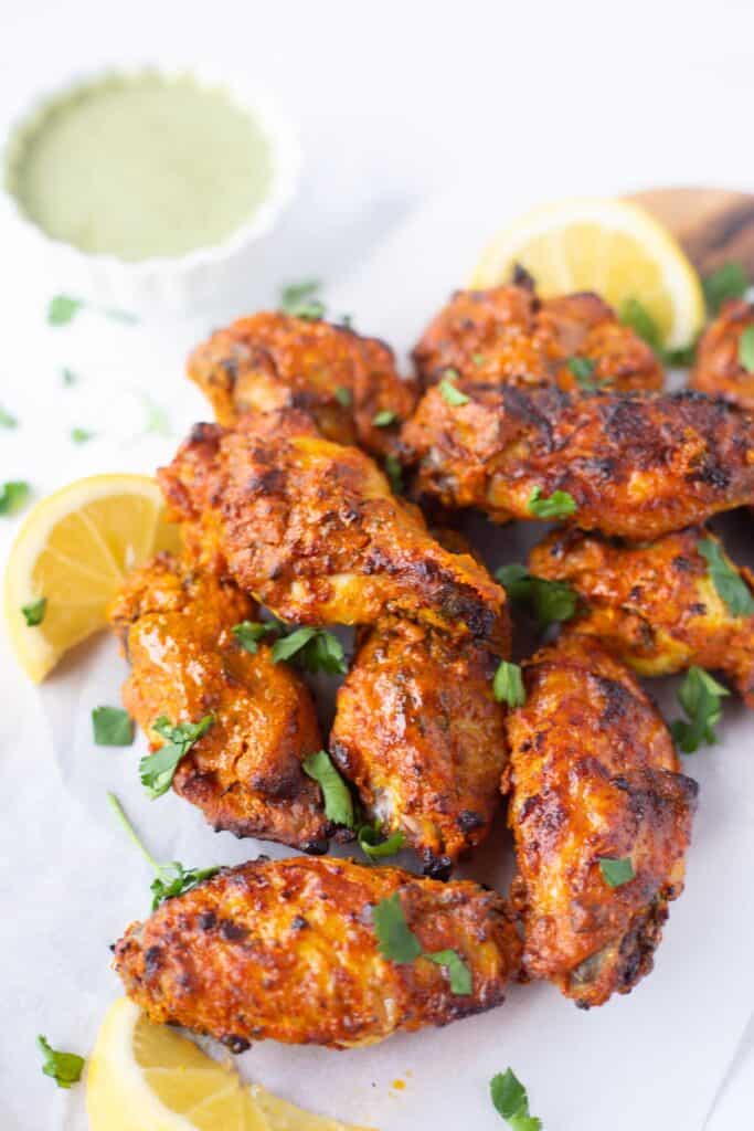 Tandoori-Chicken-Wings-Masala-Indian-Recipe-Piping-Pot-Curry on a plate sprinkled with green onions