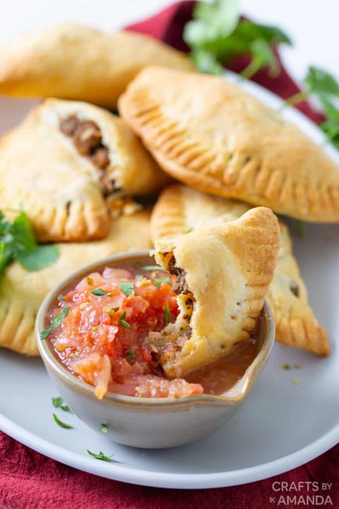 Empanadas served with salsa on a white backdrop