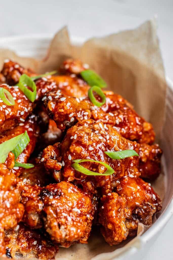 Crispy chicken covered in sauce topped with sesame seeds and green onion