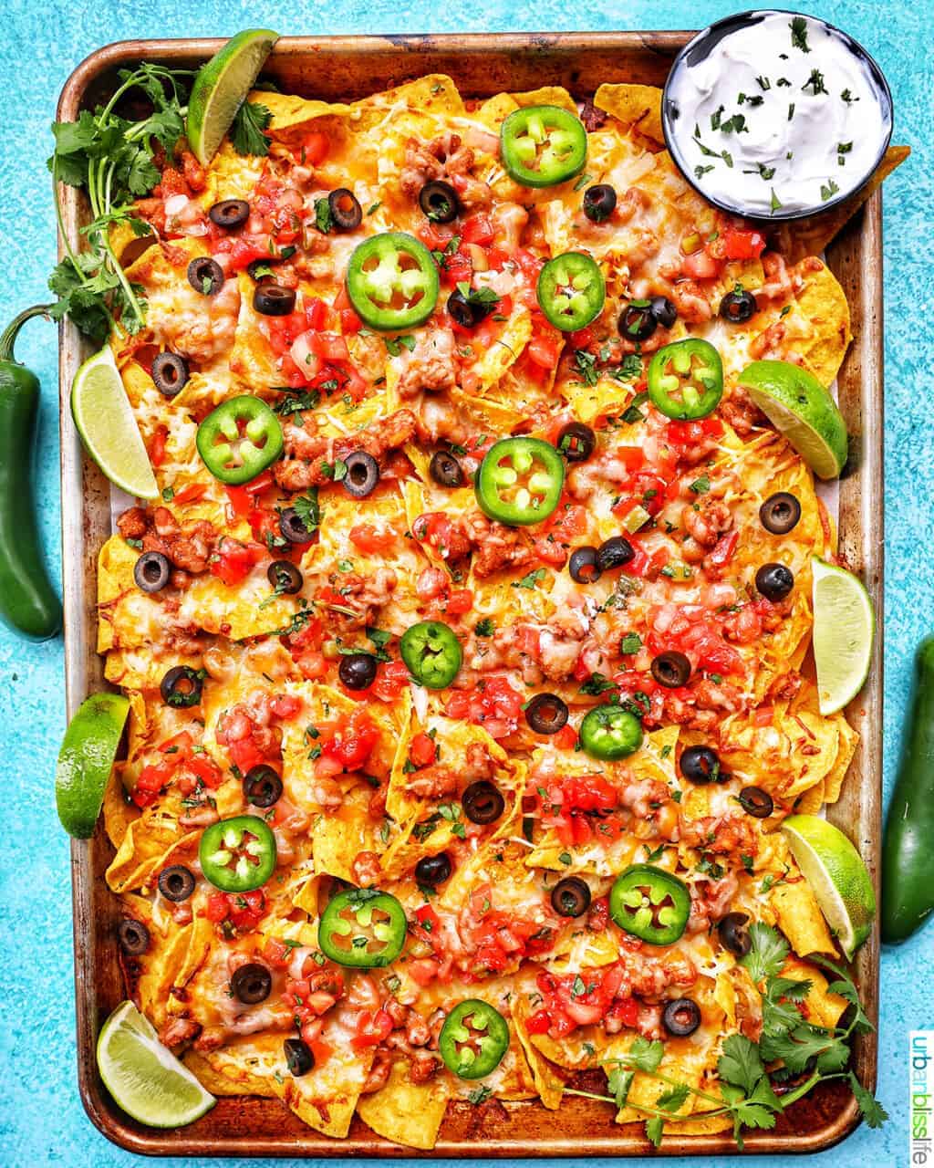 Sheet pan filled with nachos with melted cheese.