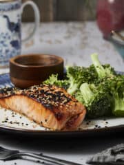 Broiled honey miso salmon on a plate with sesame seeds and broccoli.