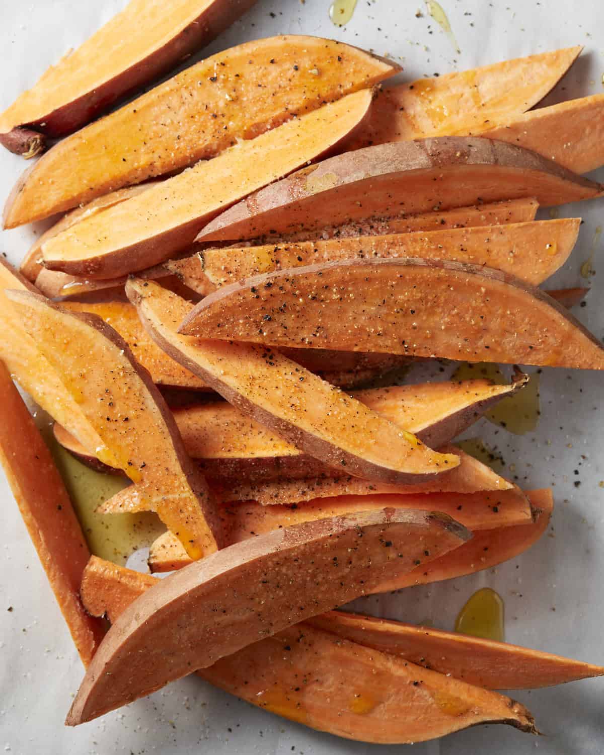 Toss and seasoning of sweet potato wedges.