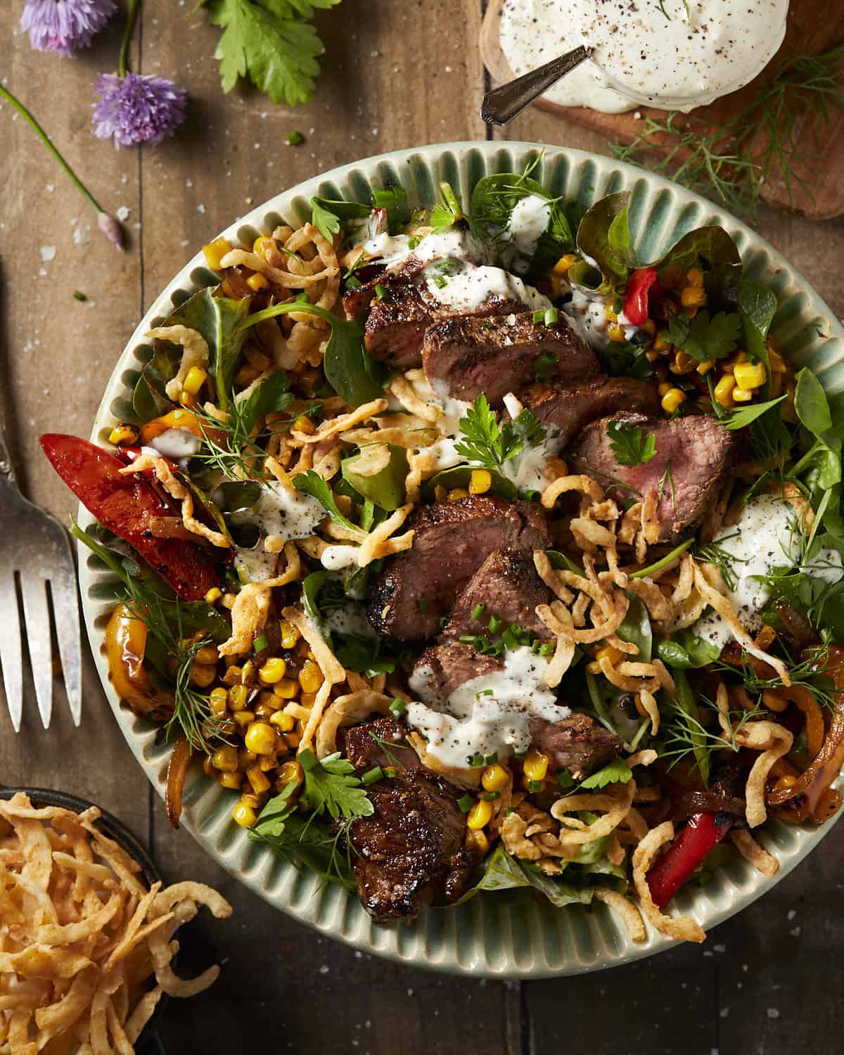 Steak salad with peppers, fried onions and blue cheese dressing.