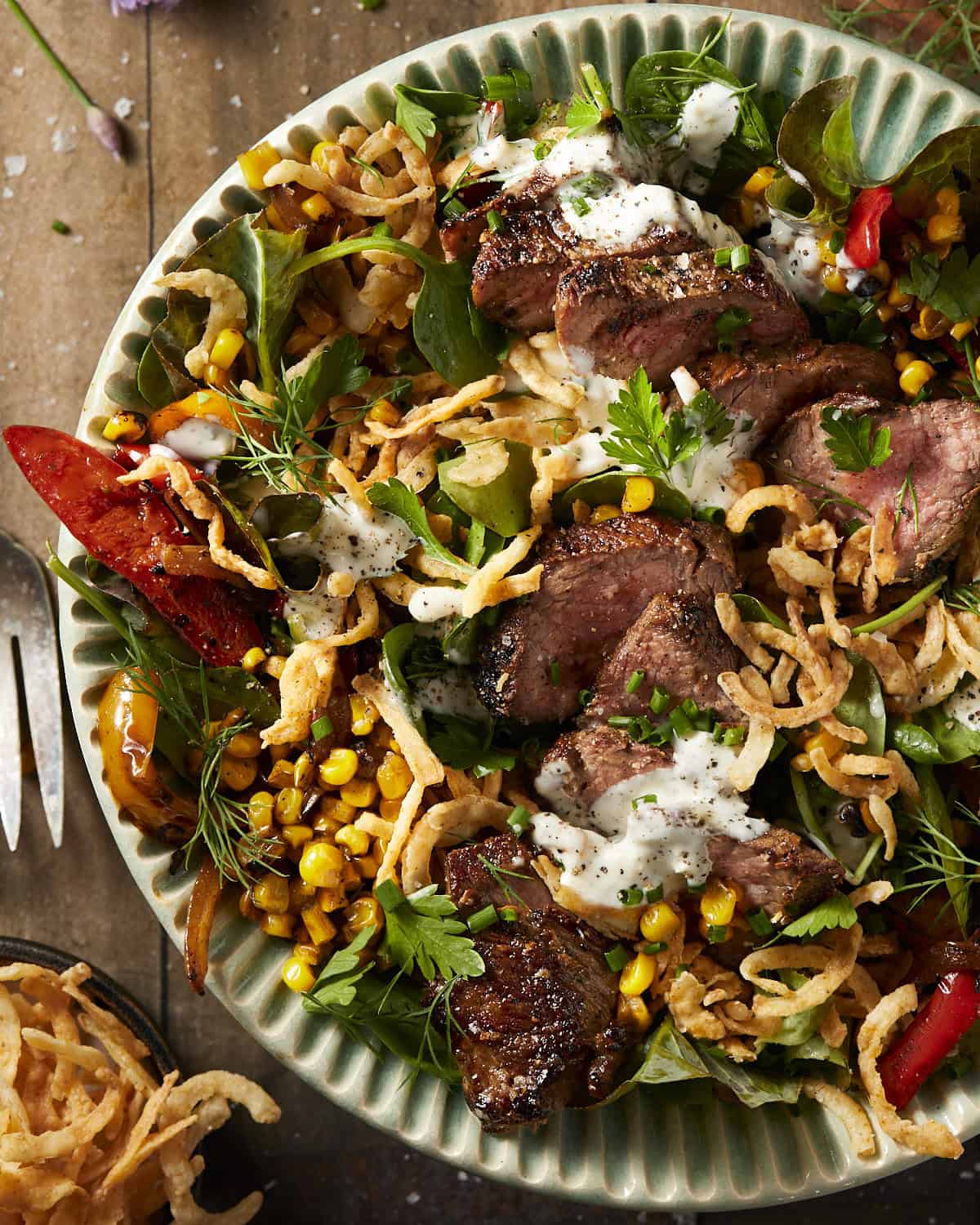 Steak and blue cheese salad in a blue bowl. 