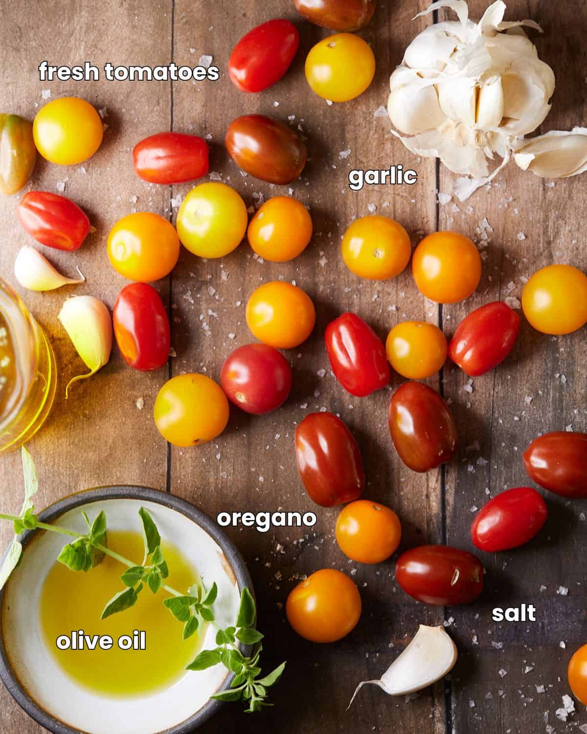 Ingredients needed to make roasted tomatoes on a wooden backdrop.