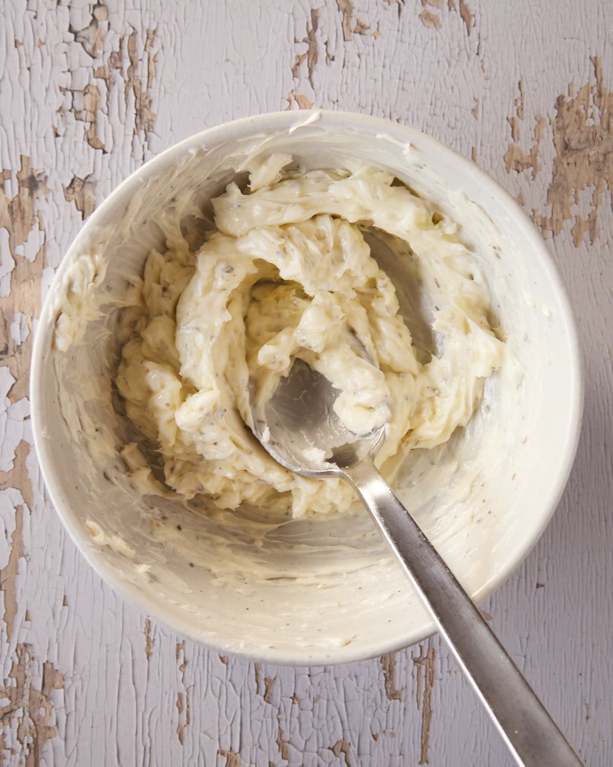 A bowl full of garlic herb butter for garlic bread. 