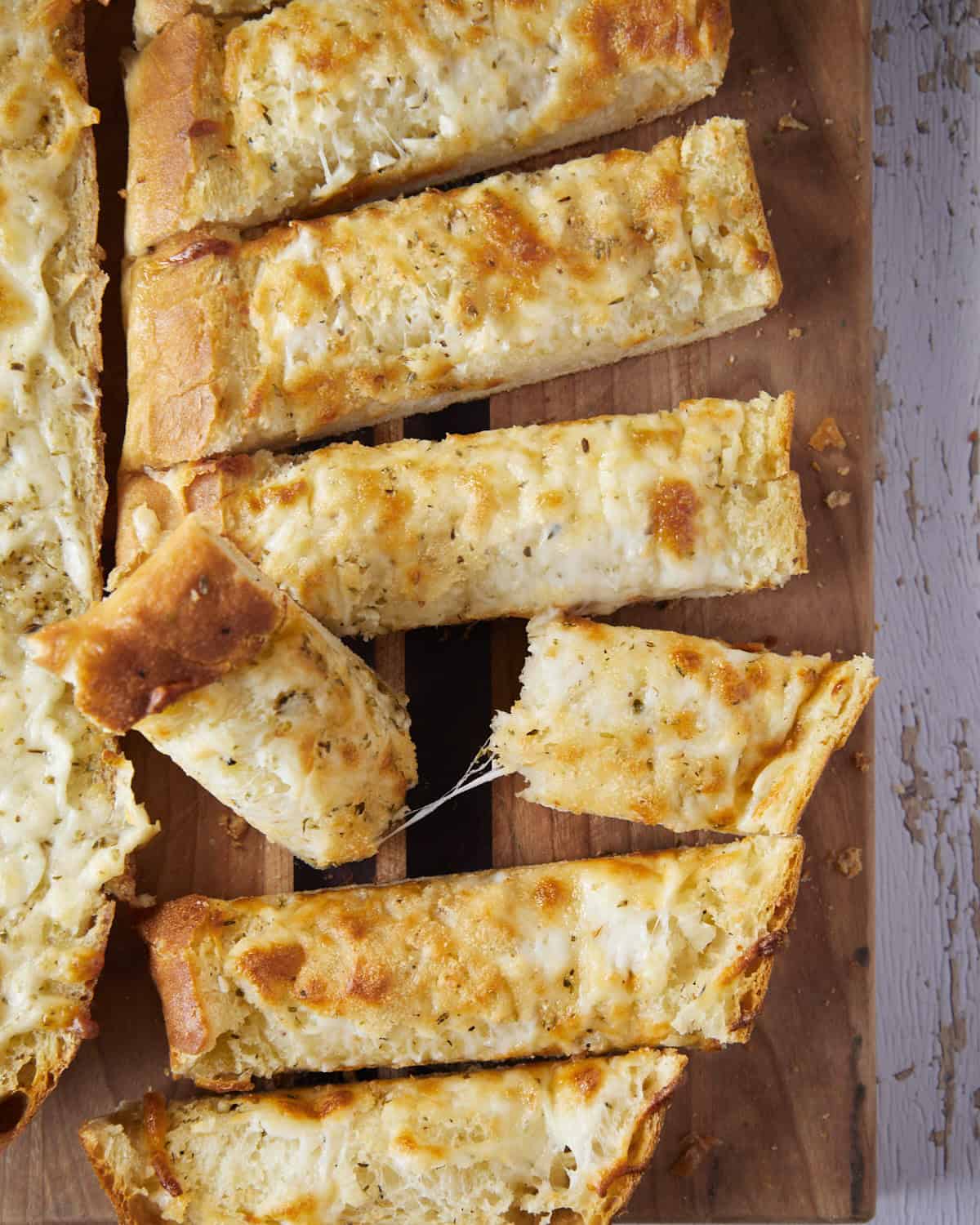 Up close of garlic bread with a cheese pull.