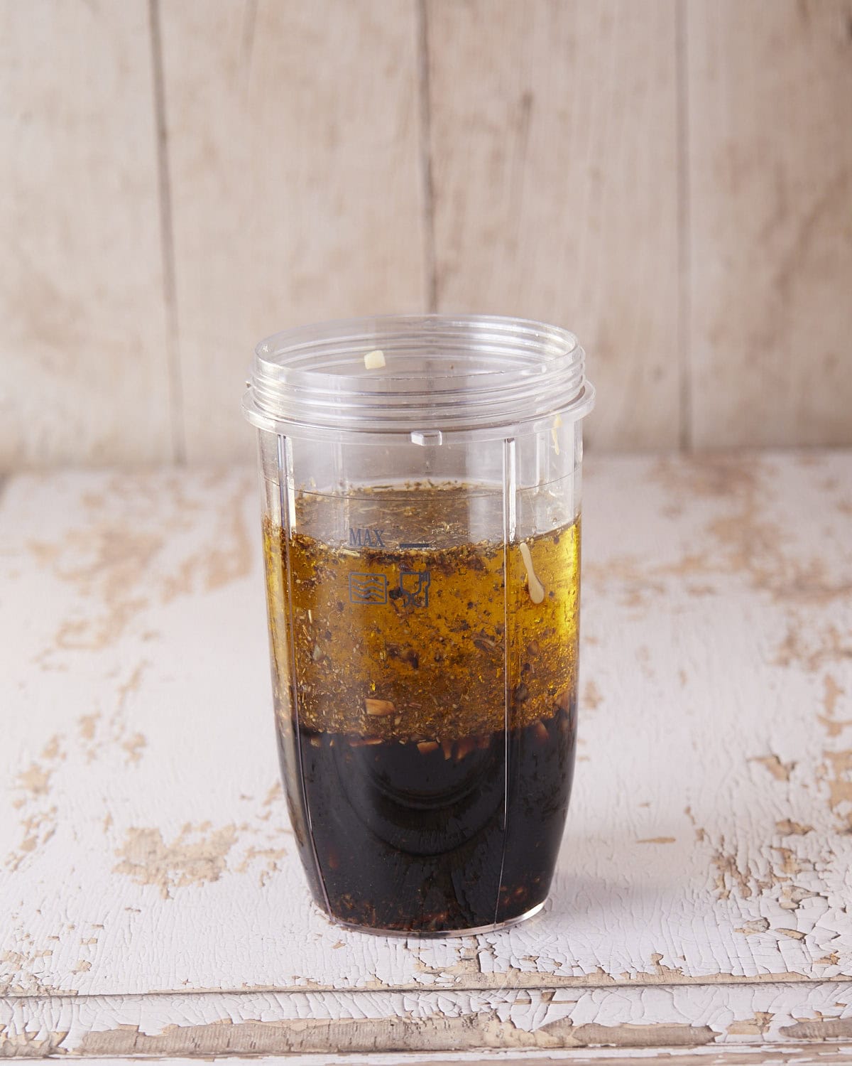 A blender jar filled with all the ingredients for balsamic vinaigrette before blending.
