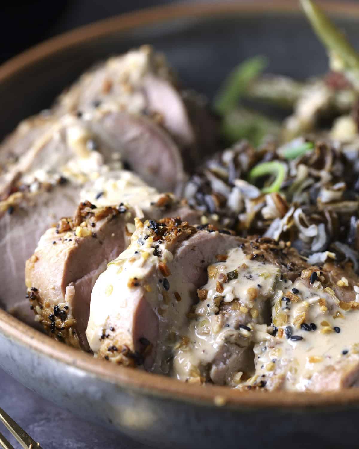Close up of sliced pork tenderloin with everything bagel seasoning.