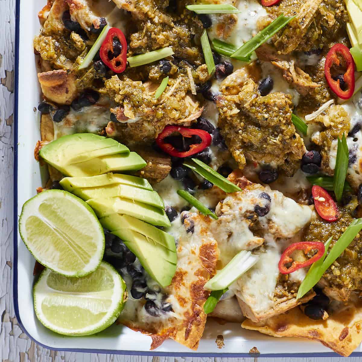 Sheet pan nachos with a pork chile verde sauce.