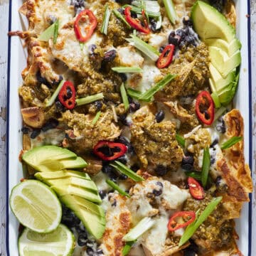 Sheet pan nachos with pork chile verde sauce and melted cheese.