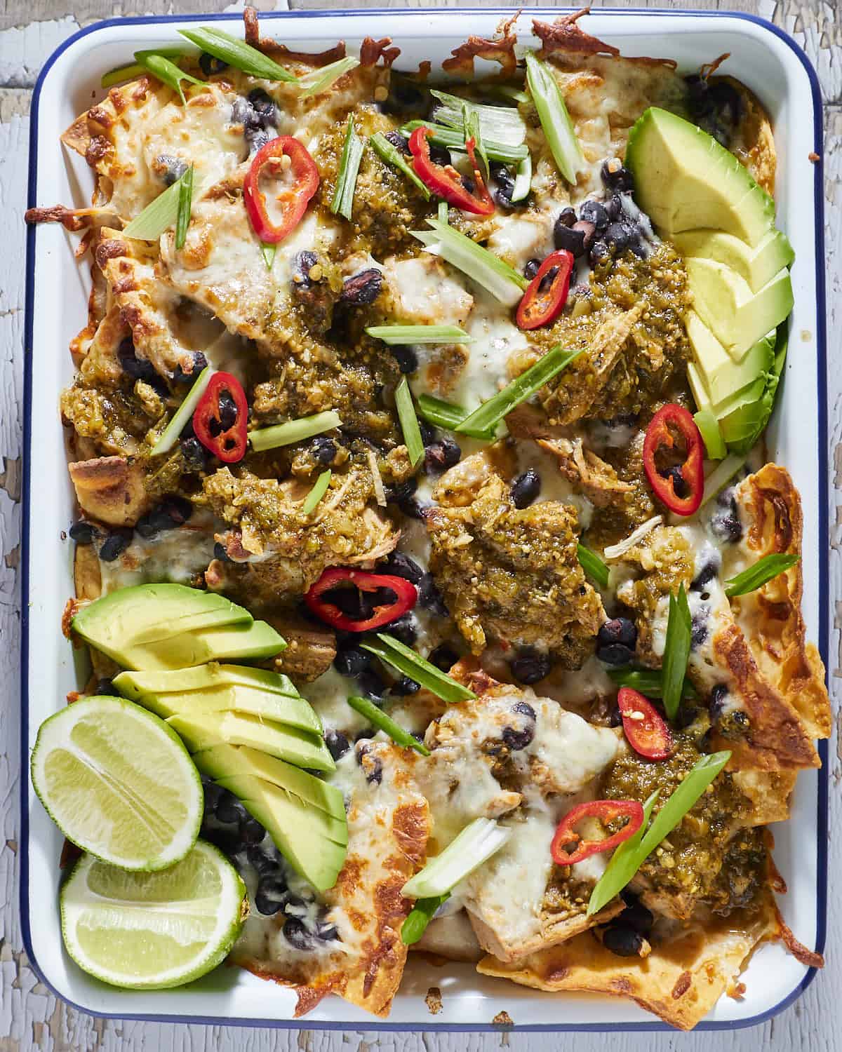 Sheet pan nachos with pork chile verde sauce and melted cheese. 