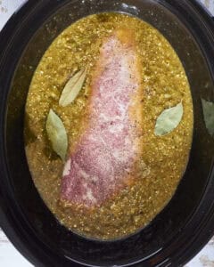 Chile verde with pork tenderloin in the slow cooker ready to be cooked.